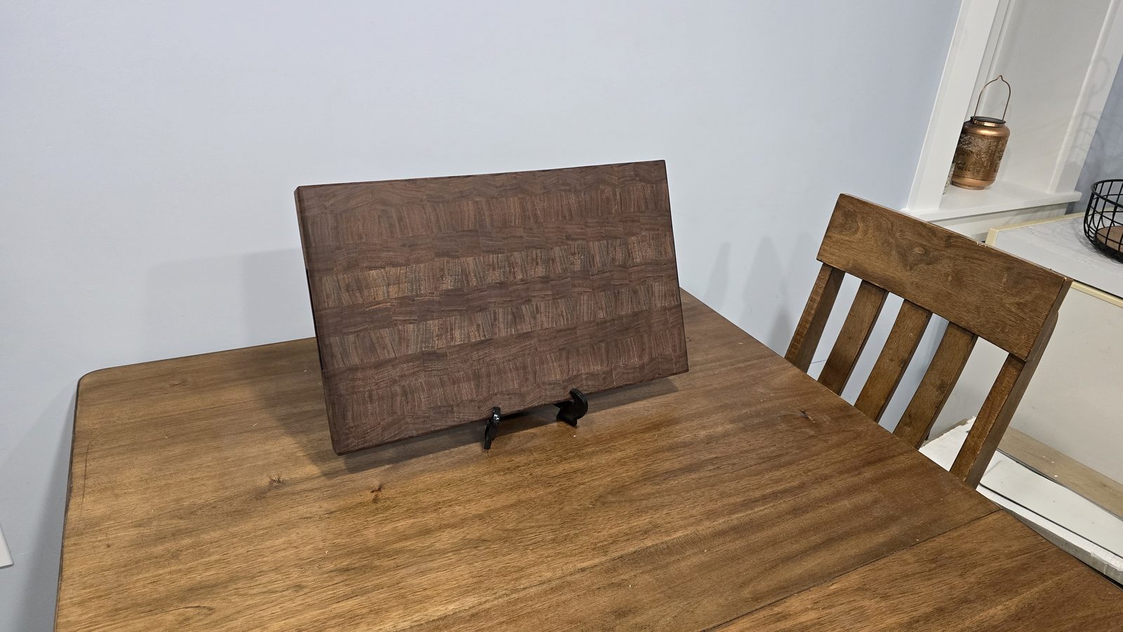 End-grain walnut cutting board on a display stand