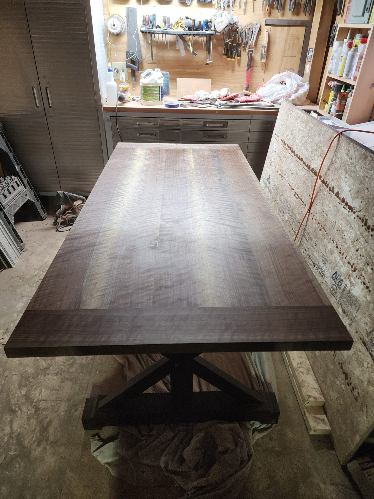 Walnut dining table on its trestle base during the build