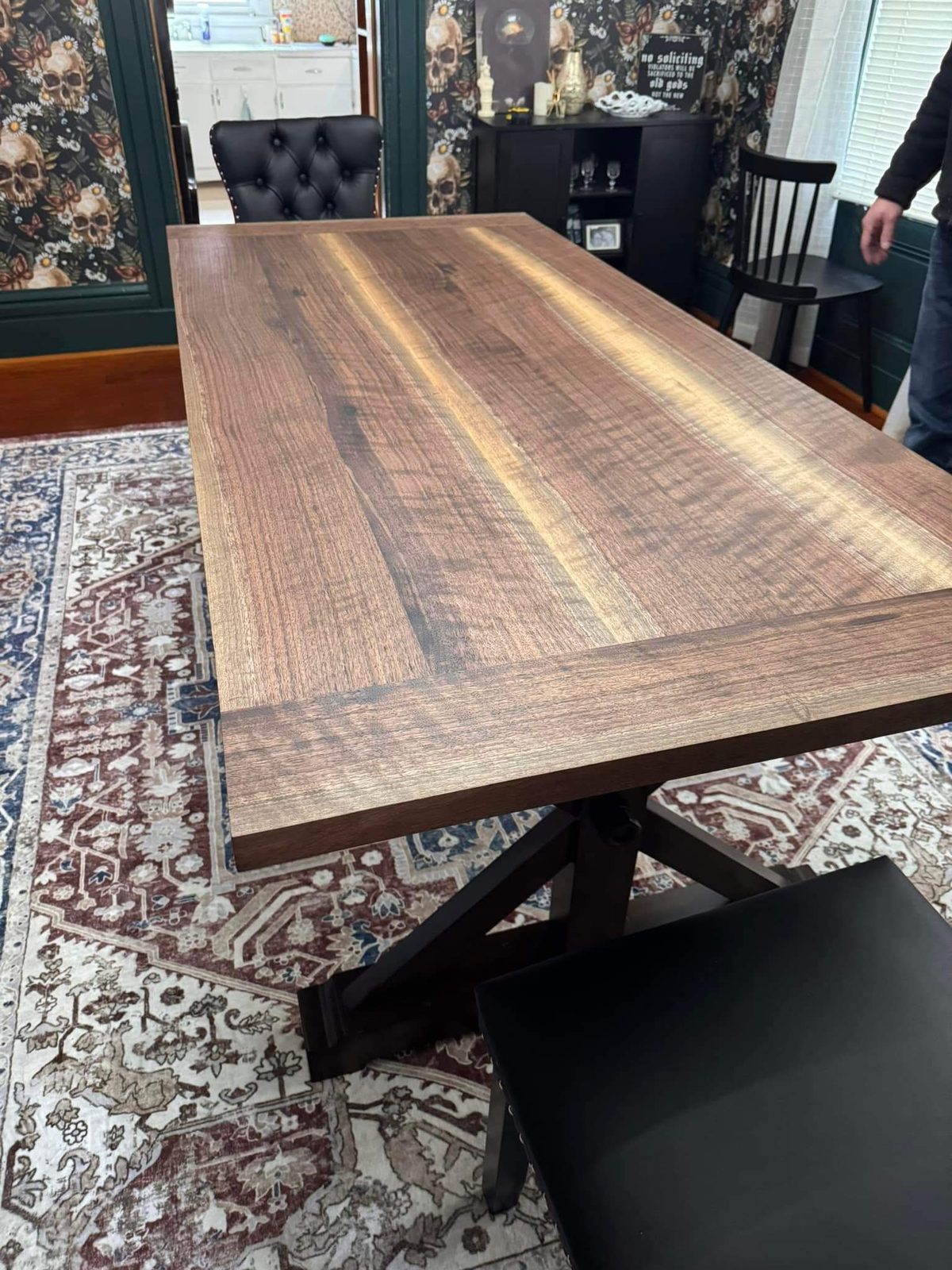 Finished walnut dining table on its trestle base in a dining room